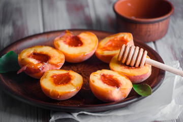 Ripe peaches on a table with tasty honey