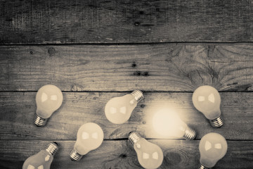 Vintage bulbs on wooden background - idea, innovation, teamwork and leadership concept. Space for text