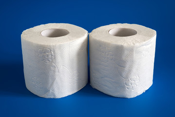 Two Roll of white soft toilet paper on blue background