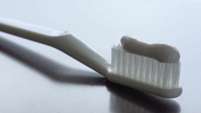 Toothpaste is being squeezed on a toothbrush. Close-up footage