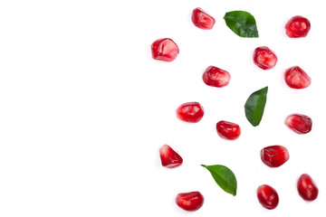 pomegranate seeds with leaves isolated on white background with copy space for your text. Top view. Flat lay pattern