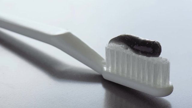 Toothpaste is being squeezed on a toothbrush. Close-up footage