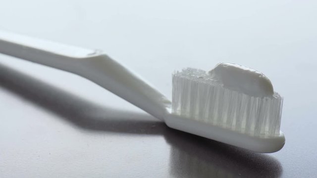 Toothpaste is being squeezed on a toothbrush. Close-up footage