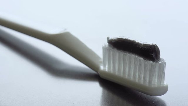 Toothpaste is being squeezed on a toothbrush. Close-up footage