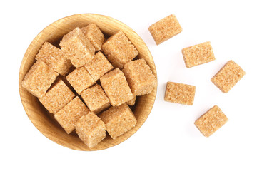 brown sugar cubes in a wooden bowl isolated on white background. Top view. Flat lay