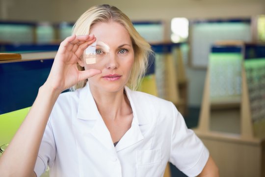 Optician holding large lens