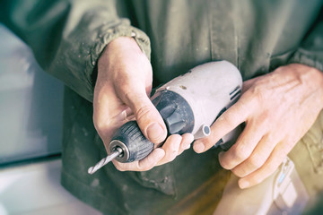 Carpenter keeps an electric drill in the hands