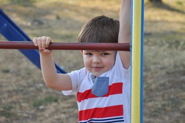 Fototapeta premium Happy boy playing on the playground. Smiling child play in park