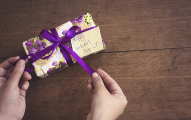 hand woman open a purple gift for valentine's