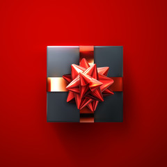 Black gift box with glittering red bow and ribbons.