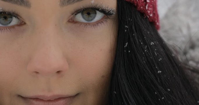 Close-up of woman face, she open eyes and blinking at frost winter