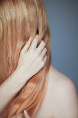 Fototapeta premium Close up woman hands maintain, comb her hair, sensual look studio portrait beauty