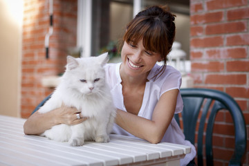 Mujer joven con gato blanco