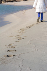 Vertical View of a Person Walking on Sand Making Footprints