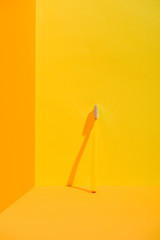 yellow toothbrush standing at orange wall