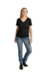 Fototapeta premium full length portrait of blonde girl wearing black shirt and jeans, standing pose isolated on a white background.