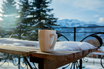 White cup with drink on wooden table © Masson