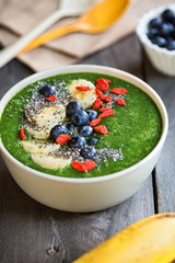 Green smoothie made of Spinach with Banana, Mango in a bowl with Blueberry ,Banana,Goji berry and  Chia seeds topping