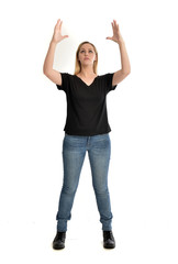 full length portrait of blonde girl wearing black shirt and jeans, standing pose isolated on a...