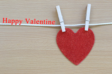 Red heart hanging on a rope and have Happy valentine text.