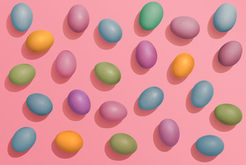 Multi colored Easter eggs on pink background, fun Easter flat lay