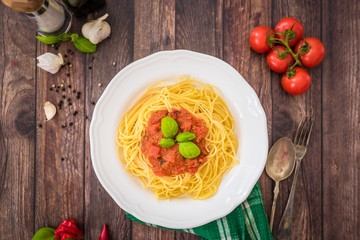 Spaghetti pasta with tomato sauce  and fresh basil - homemade healthy italian pasta on rustic wooden background