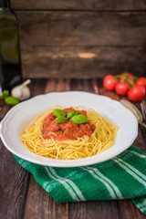 Spaghetti pasta with tomato sauce  and fresh basil - homemade healthy italian pasta on rustic wooden background
