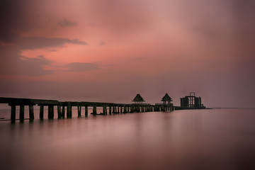 Fototapeta premium Old bridge in the sea on twilight time after sunset.