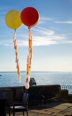 Festive balloons attached to a chair at a wedding