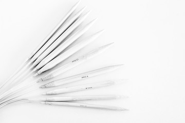 various sizes of bamboo rounded knitting needles. black and white photo