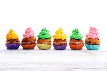 Tasty cupcakes on wooden background. Birthday cupcake in rainbow colors
