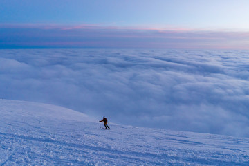 Naklejka na ściany i meble Skiing on snow in Slovak mountains above clouds during sunset in winter