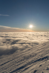 Beautiful sunset above clouds in snow covered Low Tatras mountains during susnet in winter