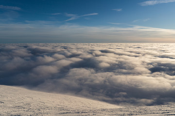 Beautiful sunset above clouds in snow covered Low Tatras mountains during susnet in winter