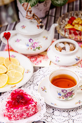 Porcelain cup of tea with lemon and sweets