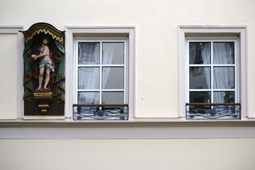 Jesusfigur am Wohnhaus / Eine Skulptur von Jesus an dem Fenster eines Wohnhauses.