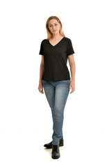 full length portrait of blonde girl wearing black shirt and jeans, standing pose isolated on a white background.