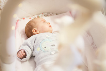 newborn baby lies in the little cradle