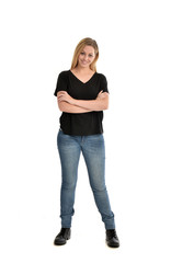 Fototapeta premium full length portrait of blonde girl wearing black shirt and jeans, standing pose isolated on a white background.