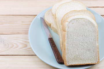 Sliced bread Stacked in green dish on wooden floor.