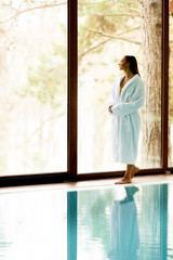 Pretty young woman relaxing by swimming pool