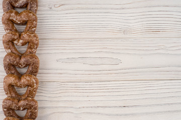 Gingerbread heart cookies on a wooden white background.