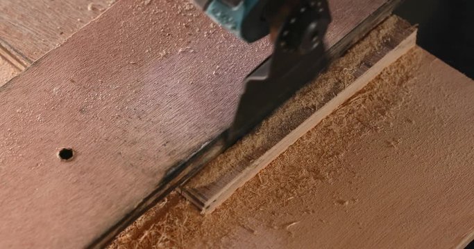 Cuts a board in the workshop