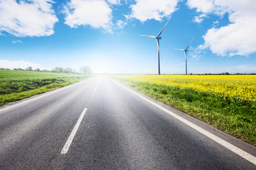 Empty road with eco-environmentally friendly wind power generation turbines of green energy