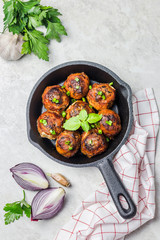 Mozarella stuffed meatballs in cast iron skillet on white stone background. Top view, copy space.