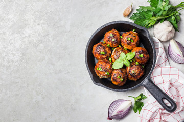 Turkey spinach cheese meatballs in cast iron skillet on white stone background. Top view, copy space.