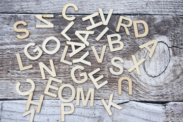 Multiple English letters of the alphabet of a wooden background 