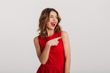 Portrait of a joyful young woman dressed in red dress