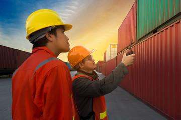 Engineer and Foreman check security and safety for the best shipping of cargo in the container yard port.