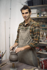 Young man making pottery in workshop